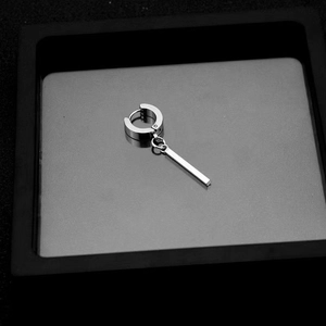 Detail view of silver stainless steel drop earrings with bar pendant in a grey display box