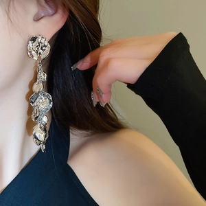 Gros plan de boucles d'oreilles argentées irrégulières avec texture de lave