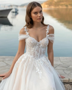 Detail of off-shoulder wedding dress featuring intricate lace embroidery and sequins