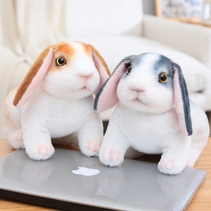 Mignons lapins en peluche à oreilles tombantes réalistes en marron et gris sur un bureau