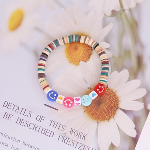 Close-up of Bohemian beaded bracelet with colorful Heishi clay beads and smiley face charms