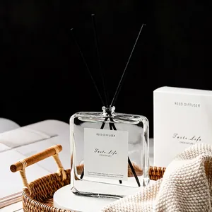 Minimalist reed diffuser set with transparent glass bottle and fiber sticks in wood basket