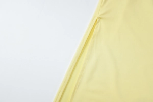 Detailed close-up of yellow dress side slit with premium stitching and smooth fabric