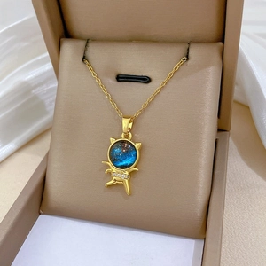 Close-up of golden cat pendant with blue nebula center and sparkling zircon stones