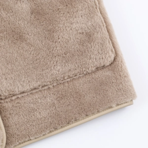 Detailed view of faux shearling texture with precise pocket stitching and leather edging