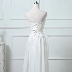 Lace bodice and vintage corset lace-up back detail of a white strapless bridal gown