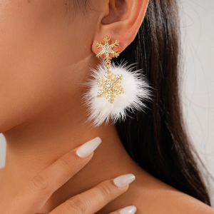Sparkling snowflake earrings with white fur balls and rhinestones shown on model