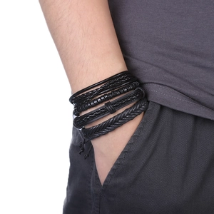 Détail d'un bracelet multicouche en cuir noir tressé avec ancre porté au poignet