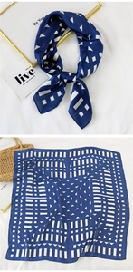 Close-up of geometric pattern silk scarf styled with decorative frame and woven bag
