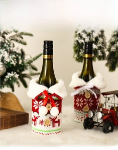 Detailed close-up of knitted Christmas wine bottle cover with reindeer and snowflake patterns