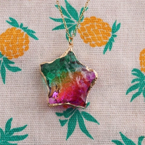Macro detail of rainbow star pendant with gold edges on stainless steel chain