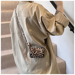 Detail of mini leopard print crossbody bag with golden buckles and long strap
