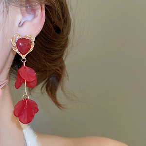 Close-up of elegant red heart petal tassel earrings worn by a model in profile