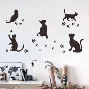 Decorative black wall stickers featuring playful cat silhouettes and paw prints for home decor