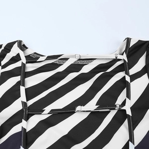 Detail of zebra stripe dress featuring thin adjustable back straps and metal buckles