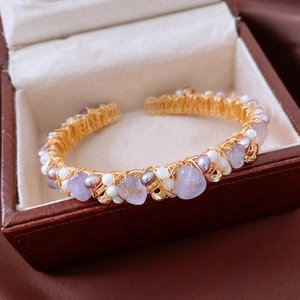 Detailed macro view of vintage 18K gold-plated wire-wrapped amethyst and pearl cuff