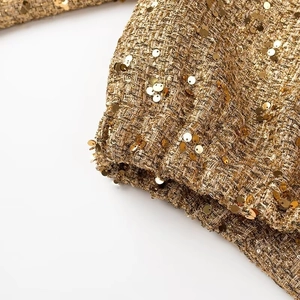 Vista macro di tessuto con paillettes dorate e trama in tweed per giacca da donna