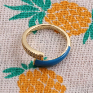Top view of gold-plated ring with blue enamel detailing and shimmering micro diamonds