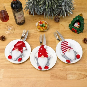 Drei Weihnachts-Gnom Besteckhalter mit roten und grauen Mützen auf einem festlichen Tisch