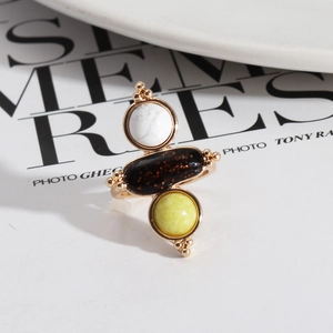 Detailed shot of retro gold ring with marble stone and black mineral on a magazine