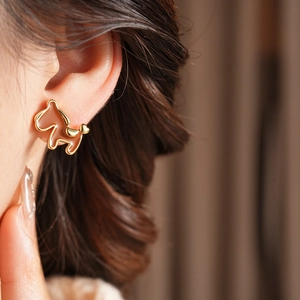 Close-up of 18K gold-plated pony earring with caramel enamel on model ear