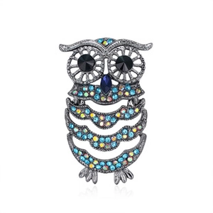 Detailed view of a vintage owl brooch with colorful rhinestones on silver metal