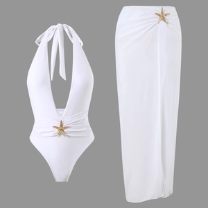 Detailed view of white bikini with gold starfish buckle and matching slit cover-up skirt