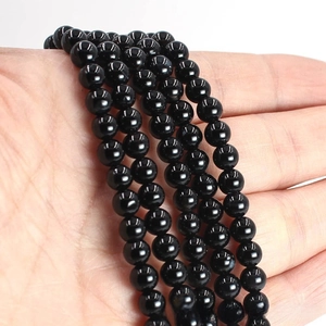 Macro detail of polished black agate round beads with a high gloss mirror finish