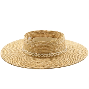 Detail of straw sun visor featuring double row pearl embellishment and woven texture
