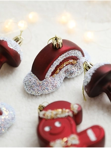 Detailed close-up of burgundy gingerbread man and rainbow ornaments with white glitter