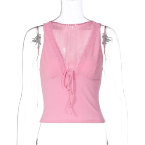 Dettaglio del gilet rosa con scollo a V profondo, bordo in pizzo e lacci sul davanti