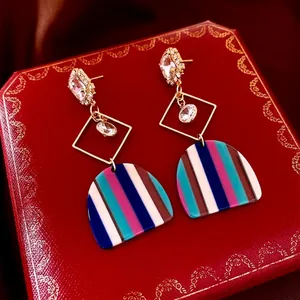 Bohemian gold tassel earrings with square cubic zirconia on a luxury red velvet gift box