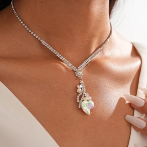 Vue détaillée du collier pendentif cœur argenté avec strass sur la clavicule du modèle