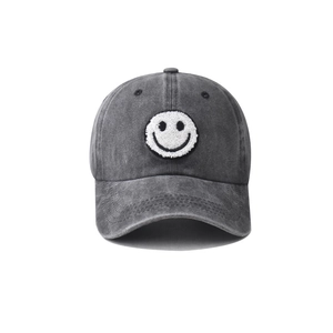Close-up of grey washed cotton baseball cap with white towel embroidered smiley face