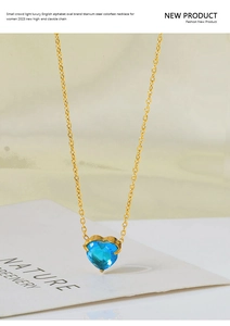 Detailed close-up of a gold titanium steel necklace with a blue heart-shaped zircon pendant