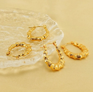 Dettaglio di orecchini a cerchio in acciaio inox 18K con design a texture di bambù