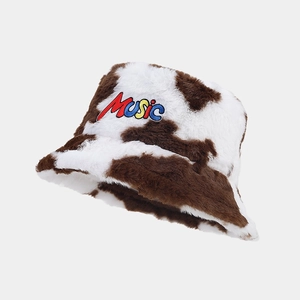 Detail of plush faux fur bucket hat with cow print and colorful Music embroidery