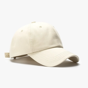 Detail view of the soft cotton twill texture on a beige minimalist baseball cap