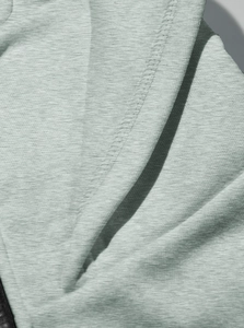 Close-up of light grey knit fabric with detailed double stitching and ribbed texture