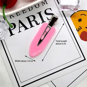 Close-up of pink resin hair clip with 6cm length dimension on a white display card