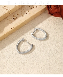 Macro shot of V-shaped S925 sterling silver hoop earrings with white moissanite stones