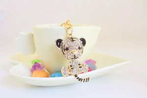 Close-up of golden tiger keychain featuring sparkling rhinestones and black enamel detail