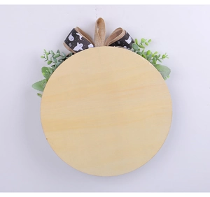 Close-up of wooden Halloween door sign with artificial greenery and BOO ghost ribbon