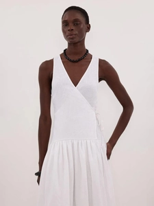 Détail de la robe portefeuille blanche en coton avec col en V, taille nouée et texture de tissu
