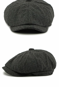 Macro detail of dark grey herringbone wool newsboy cap showing textured fabric weave
