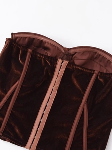 Detailed view of dark brown velvet corset top with row hook closures and inner stitching
