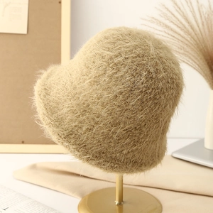 Winter plush bucket hat in beige faux mohair displayed on a metal hat stand