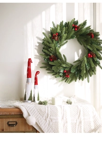 Christmas gnome statues and berry wreath on a wooden counter for holiday home decor