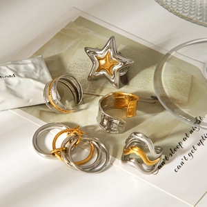 Detailed view of bicolor stainless steel rings with star and textured wave designs