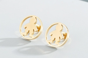 Macro detail of gold hoop earrings featuring a creative boy silhouette in cutout design